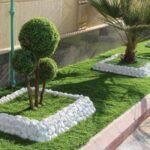 مصمم حدائقمنزلية تنسيق حديقة أمامية لفيلا بالكويت، تجمع بين العشب الطبيعي وممرات حجرية ونباتات استوائية بلمسة عصرية.